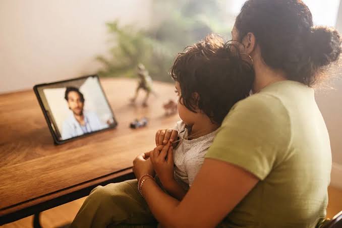 A parent and child on a video call with a healthcare provider