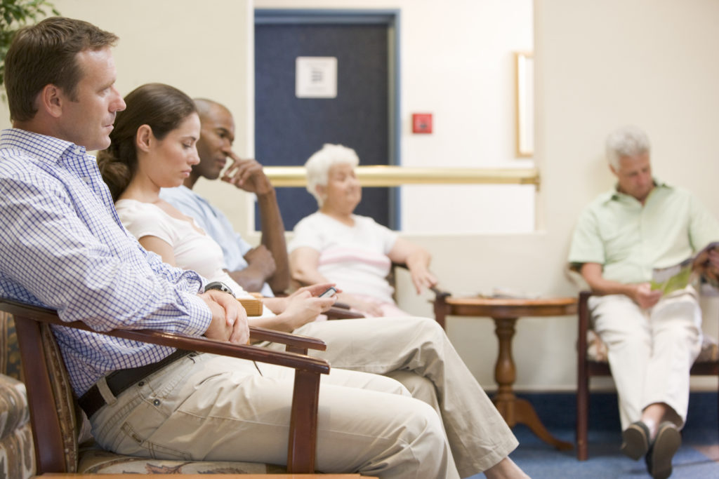 Patients waiting in a traditional clinic waiting room