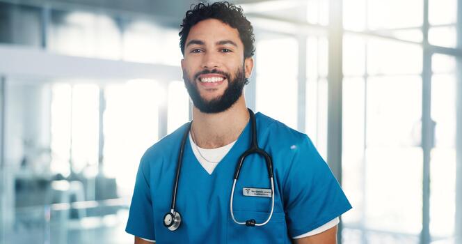 Portrait of a smiling male physician in blue scrubs with a stethoscope